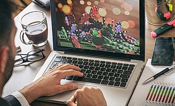 A man looking at game chips in a laptop